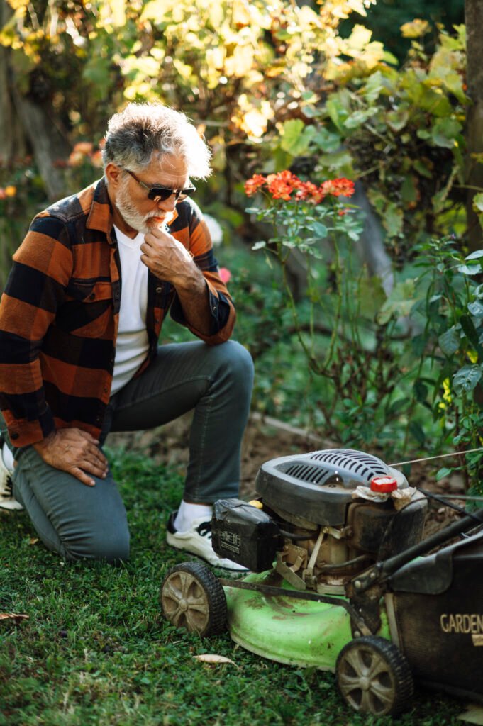 Person inspecting a lawn mower during routine maintenance