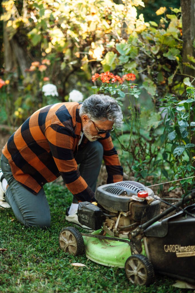Person repairing a lawn mower in a garden