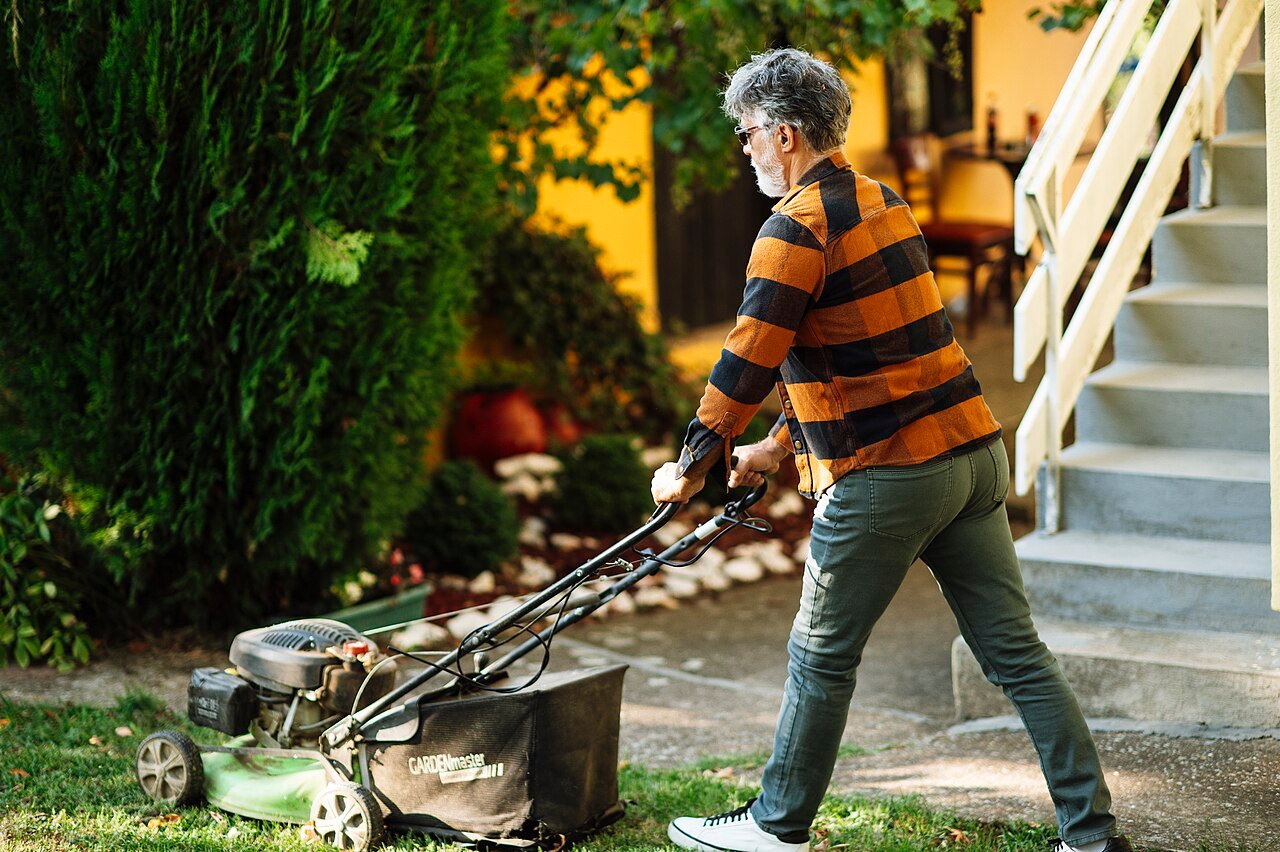 Man mowing a lawn in a suburban garden